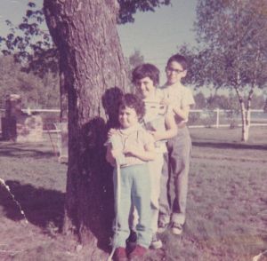 My sister, me, and my brother facing our bungalow. Behind us you can see Kauneonga Lake. About 1962.